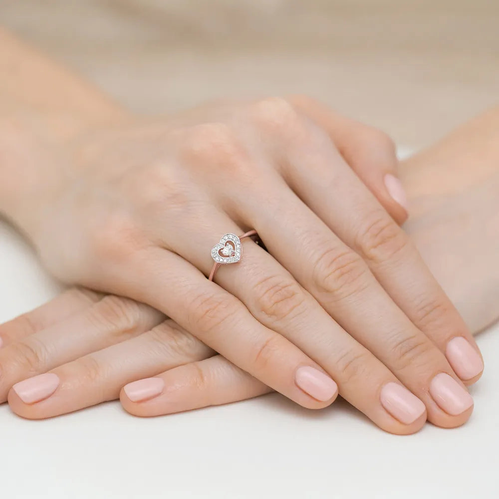 Ring aus 14 Karat Roségold mit einem 0,10 ct Diamanten und 18 Diamanten mit einem Gesamtgewicht von 0,09 ct. Der Ring wird in einer schwarzen Schachtel, Papier und Geschenktüte verpackt.