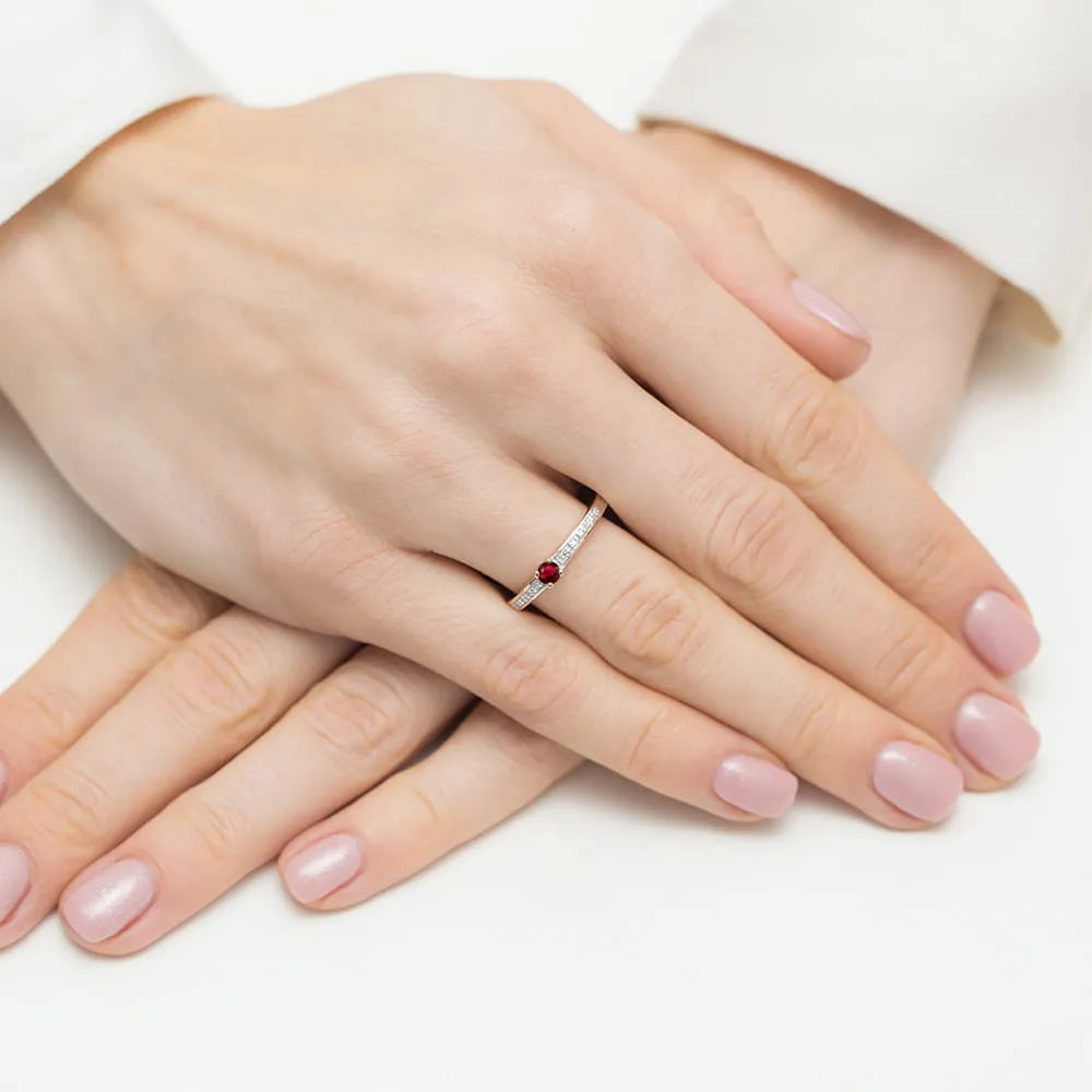 Ring aus 14 Karat Roségold mit 0,15 ct Rubin und 0,05 ct Diamanten. Verpackt in schwarzer Schachtel, Papier und Geschenktüte.
