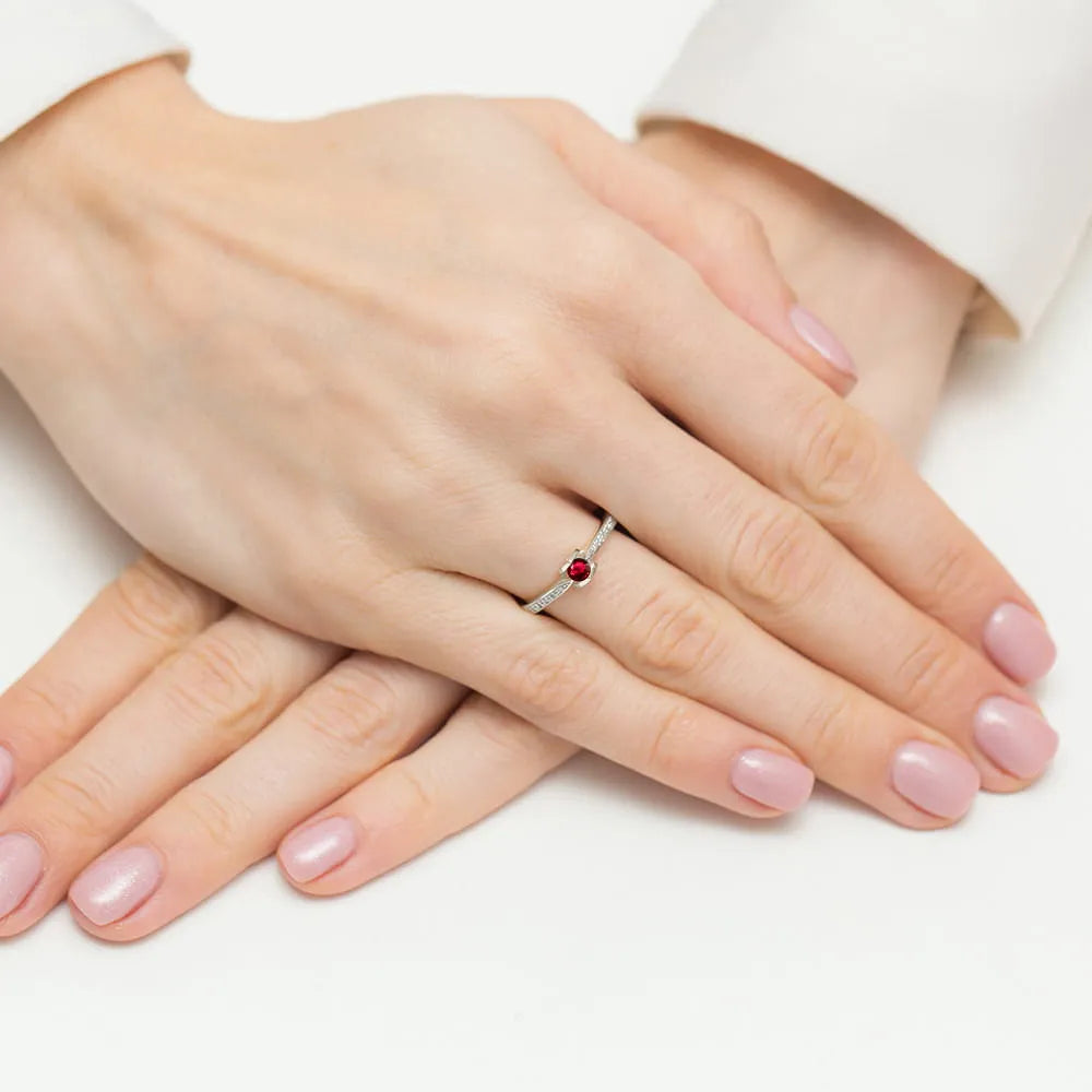 Ring aus 14 Karat Weißgold mit 0,15 ct Rubin und 0,05 ct Diamanten. Verpackt in schwarzer Schachtel, Papier und Geschenktüte.