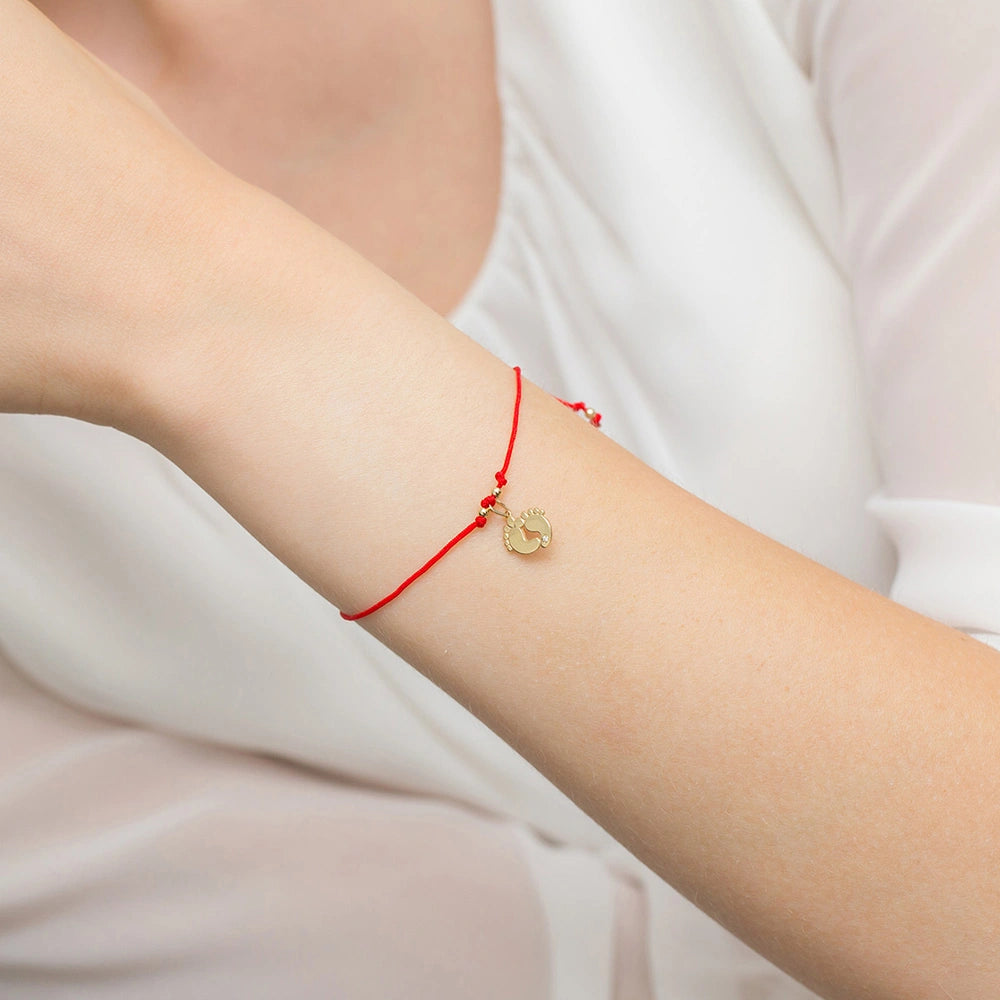 Armband mit roter Kordel und Fußabdruck-Anhänger aus 585er Gelbgold mit Diamant