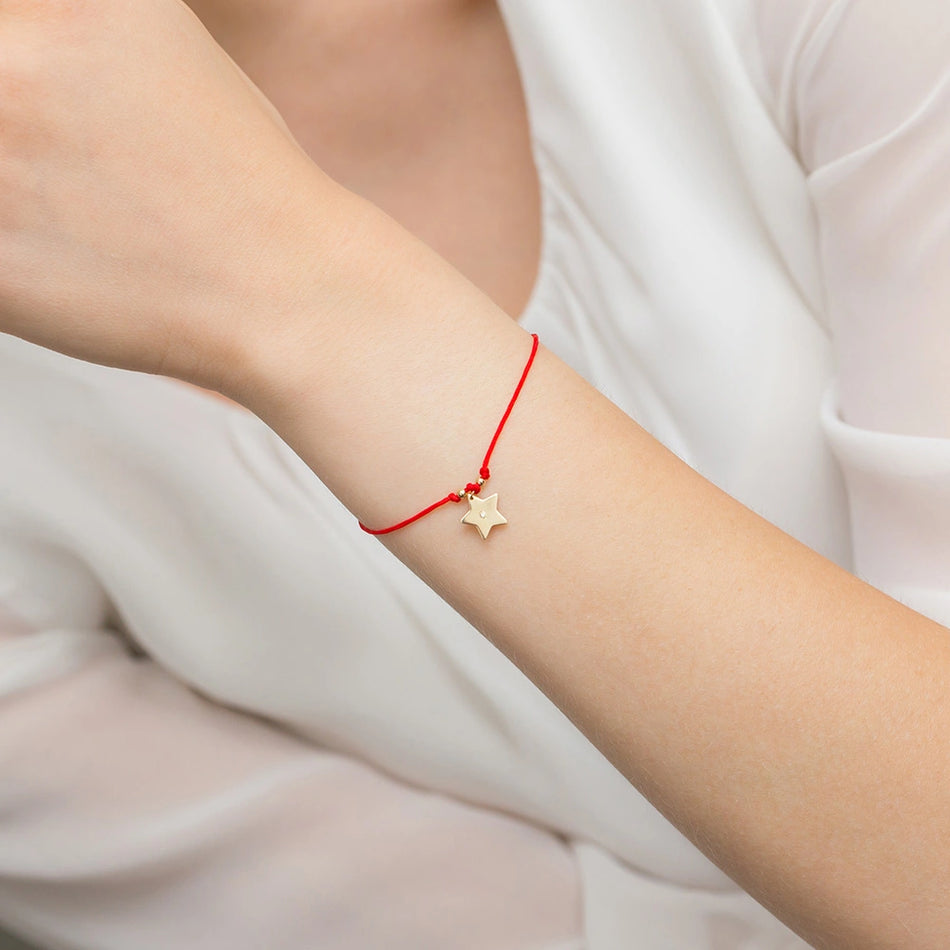 Goldarmband mit Diamantstern und rotem Band